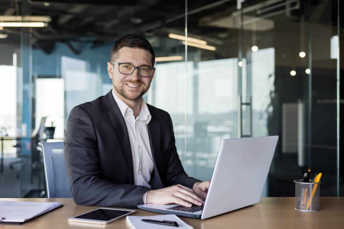 Homme d’affaires souriant travaillant sur ordinateur portable