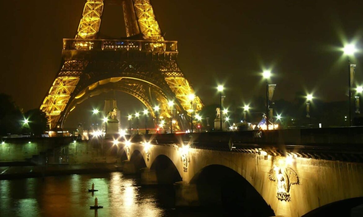 Tour Eiffel illuminée la nuit depuis un pont