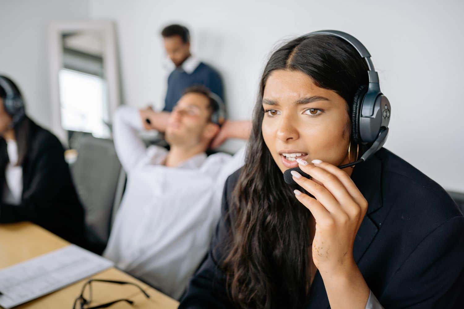 Téléconseillère stressée avec casque en open space