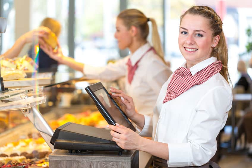 Employée de boulangerie utilisant une caisse tactile