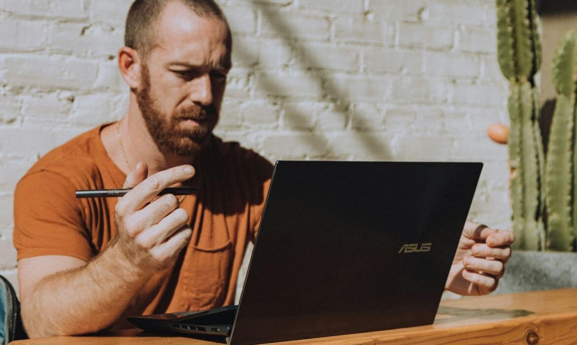 Homme travaillant sur ordinateur portable avec stylet