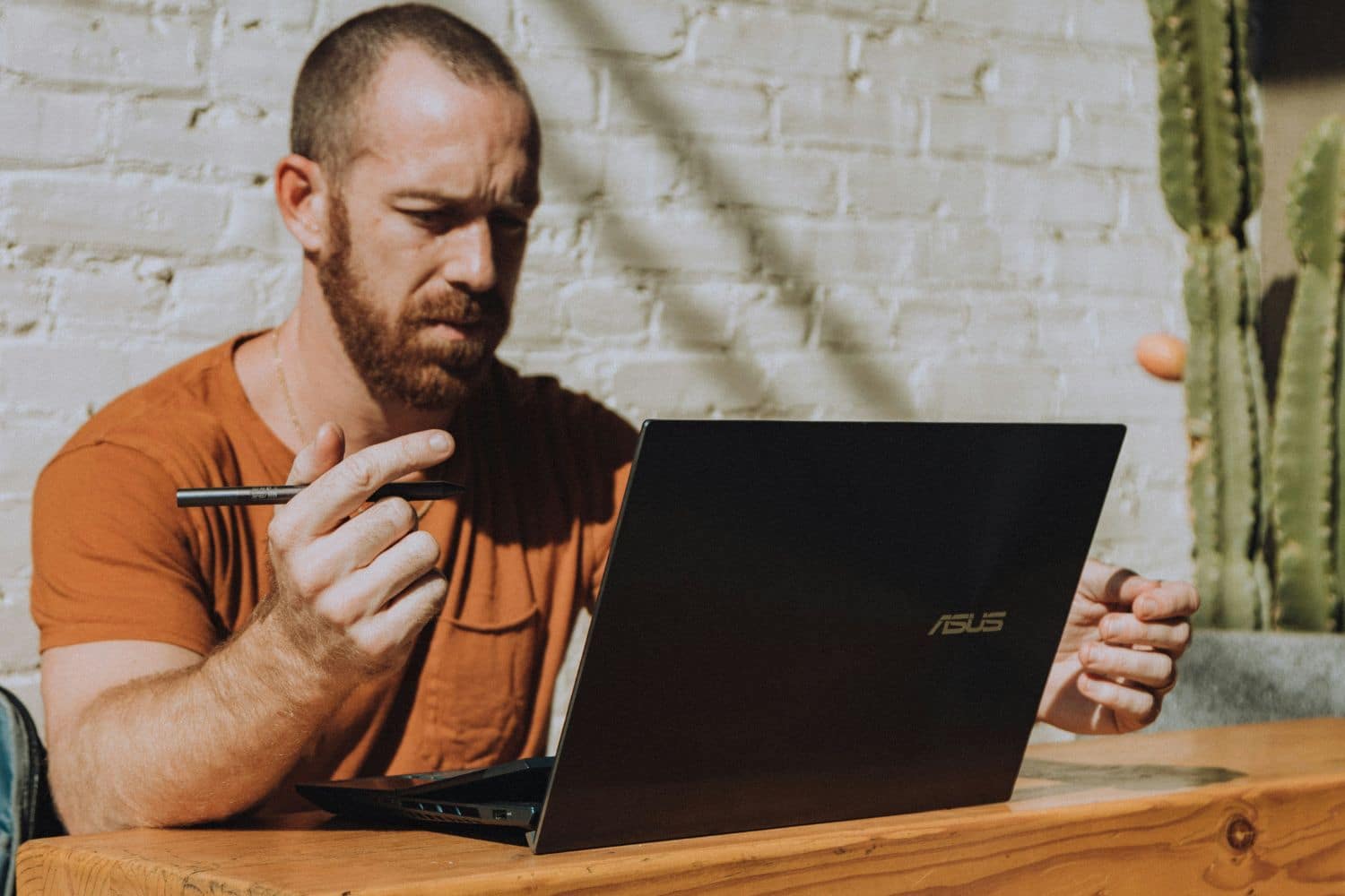 Homme travaillant sur ordinateur portable avec stylet