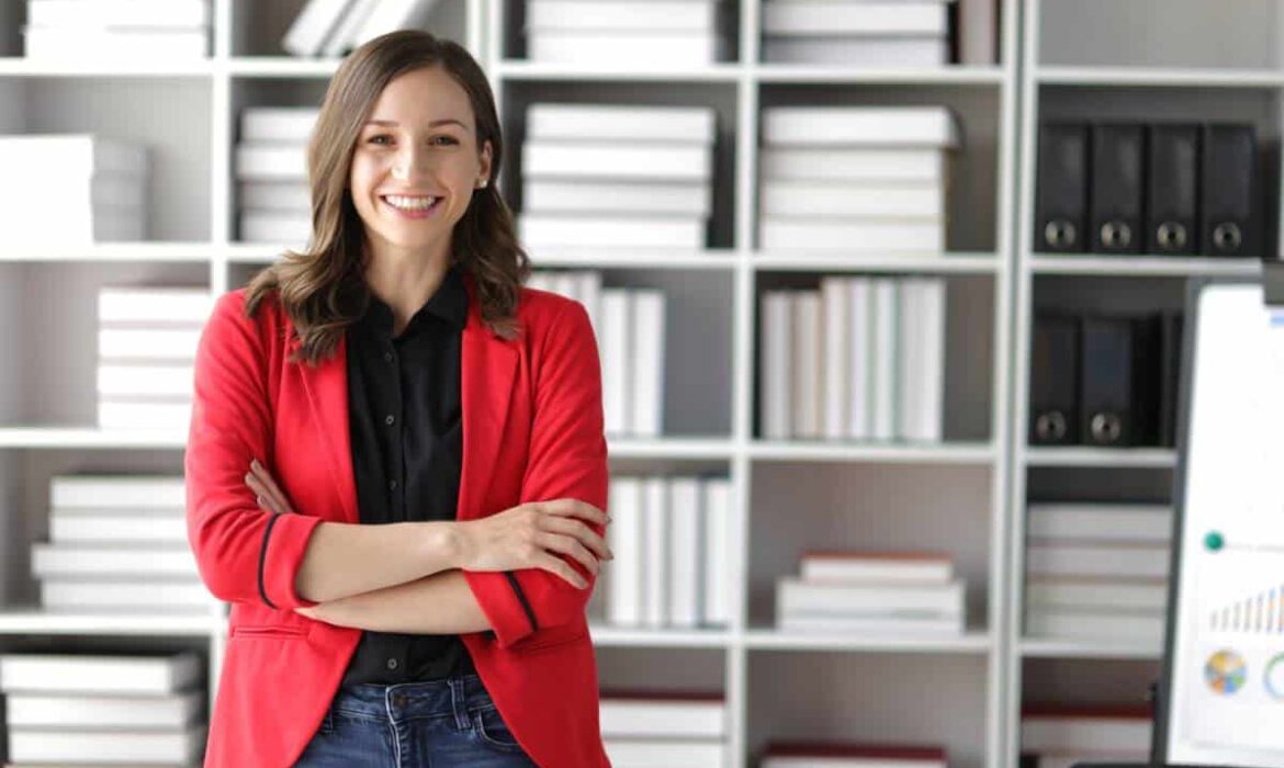 Femme souriante en blazer rouge au bureau