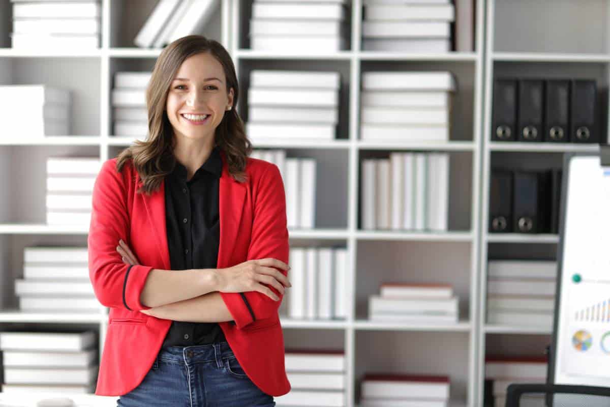 Femme souriante en blazer rouge au bureau